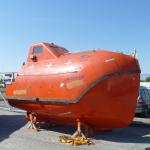 Totally enclosed free fall lifeboat with davit